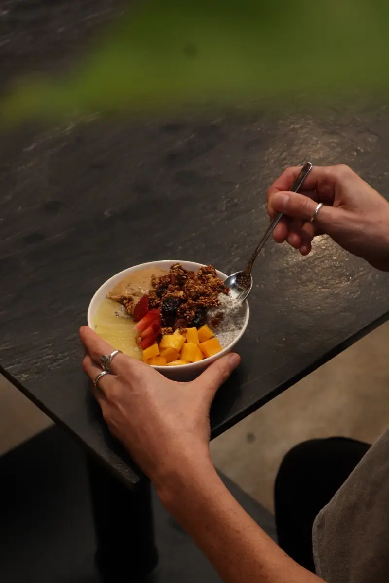 Bowl de pudding de chía con fruta y granola sobre la mesa de piedra negra
